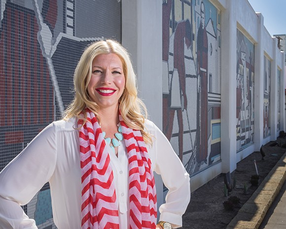 Ashleigh Davis, general manager of the  Santa Barbara Public Market, stands in front of the historic tile mural preserved and relocated along Chapala Street. (Nik Blaskovich / Business Times photo)