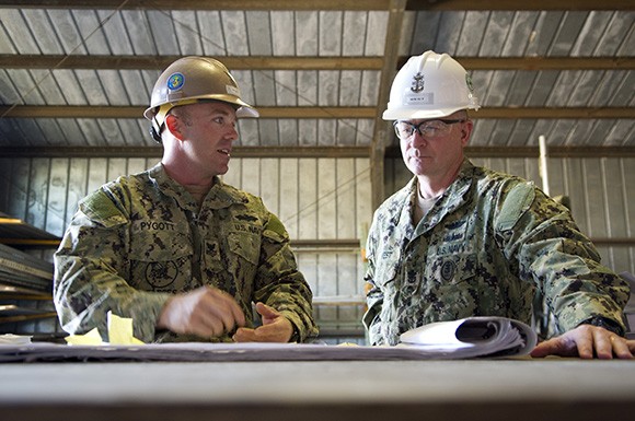 Builder 1st Class Edward Pygott, assigned to Naval Mobile Construction Battalion 3, shows Master Chief Petty Officer of the Navy Rick West construction plans for a training site the Seabees maintain during a tour in 2012 of Naval Base Ventura County. (U.S. Navy courtesy photo by Mass Communication Specialist 2nd Class Thomas L. Rosprim)