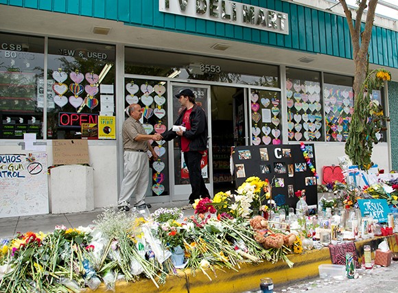 IV Deli Mart owner Sam Hassan, left, welcomes a customer to his popular Isla Vista store, which has become a memorial and gathering place since the May 23 massacre. (Business Times photo)