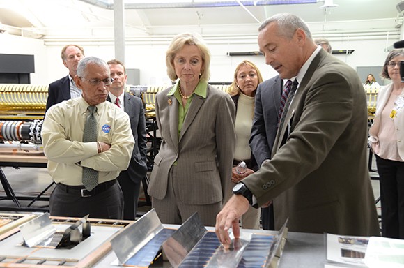 Deployable Space Systems President Brian Spence, right, shows NASA Administrator Charles Bolden, left, and Congresswoman Lois Capps how different solar cell arrangements can increase yields at a tour of the company's headquarters in Goleta on June 1. (Austen Hufford / Business Times photo)