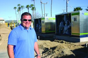 Mike Harrison of Harrison Industries poses with compressed natural gas fueling stations.